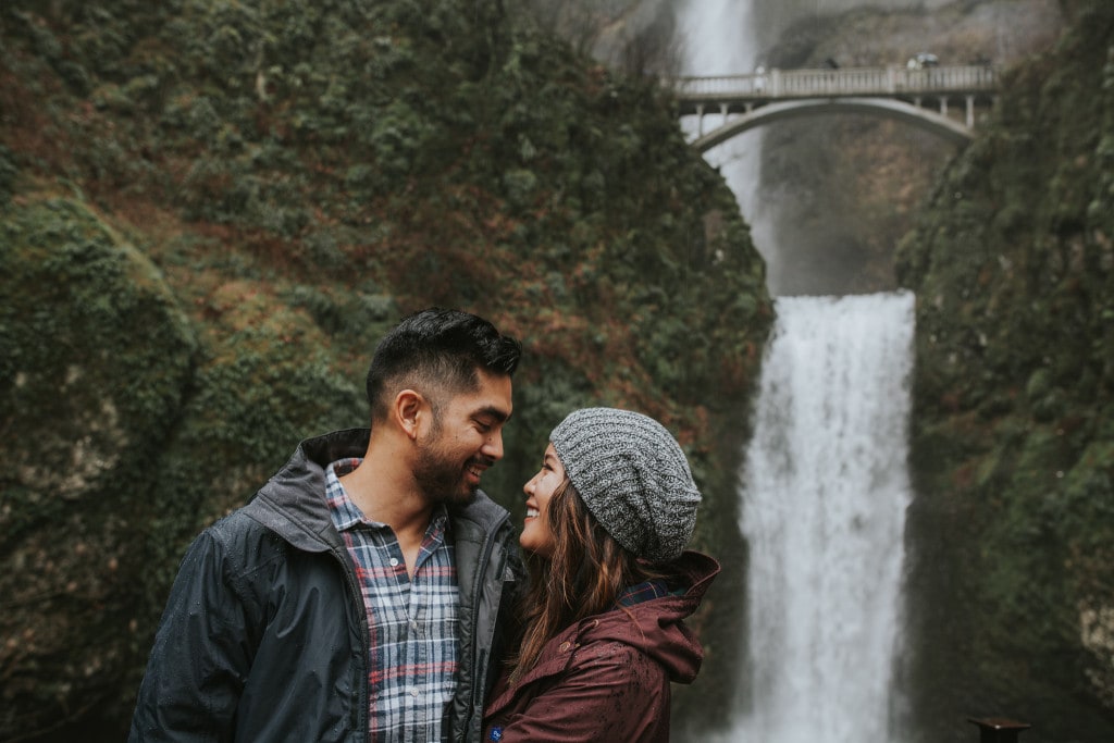 cute smiling couple in front of Multnomah Falls by Marcela Pulido Portland Wedding Photographer