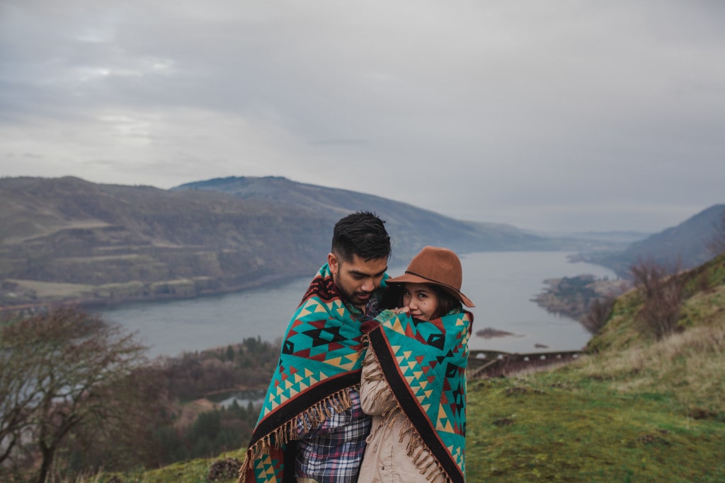 cute couple coy under blanket outdoors by Marcela Pulido Portland Wedding Photographer