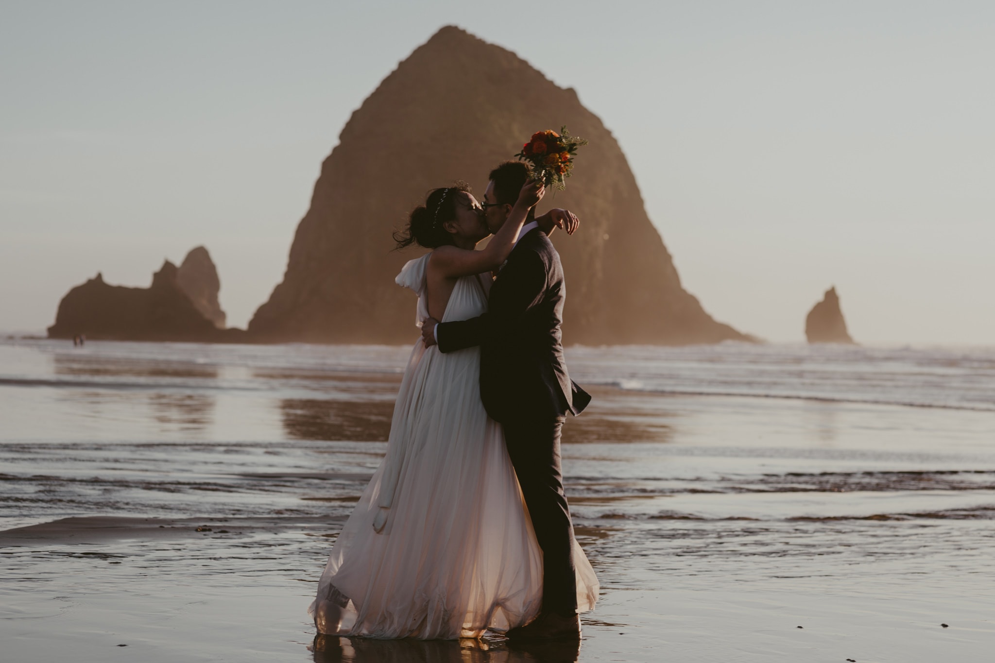 haystack rock cannon beach kiss bride and groom Portland Wedding Photographer Marcela Pulido