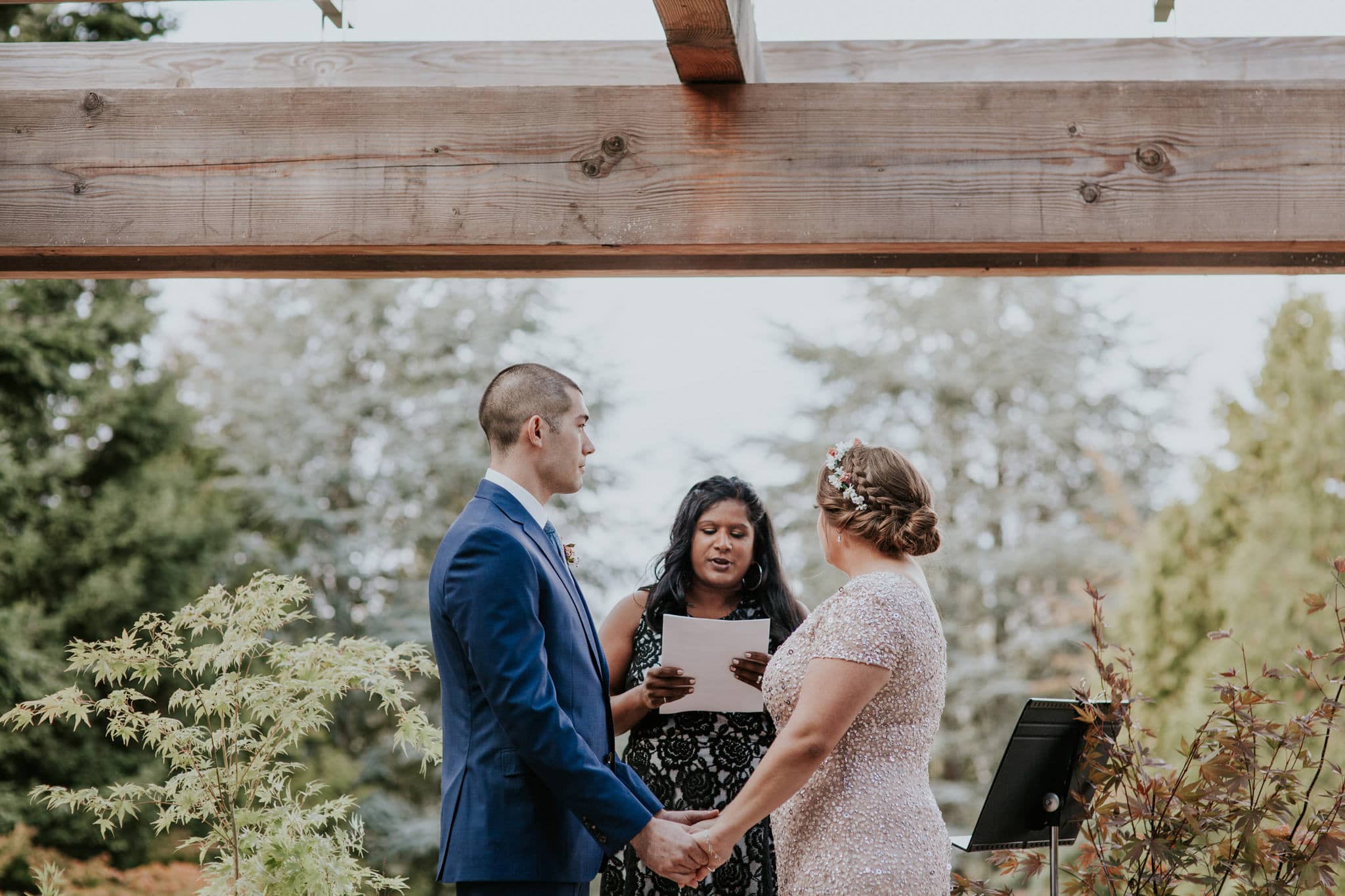 bride and groom hold hands during ceremony Kubota Garden Wedding by Marcela Pulido Photography Portland Wedding Photographer