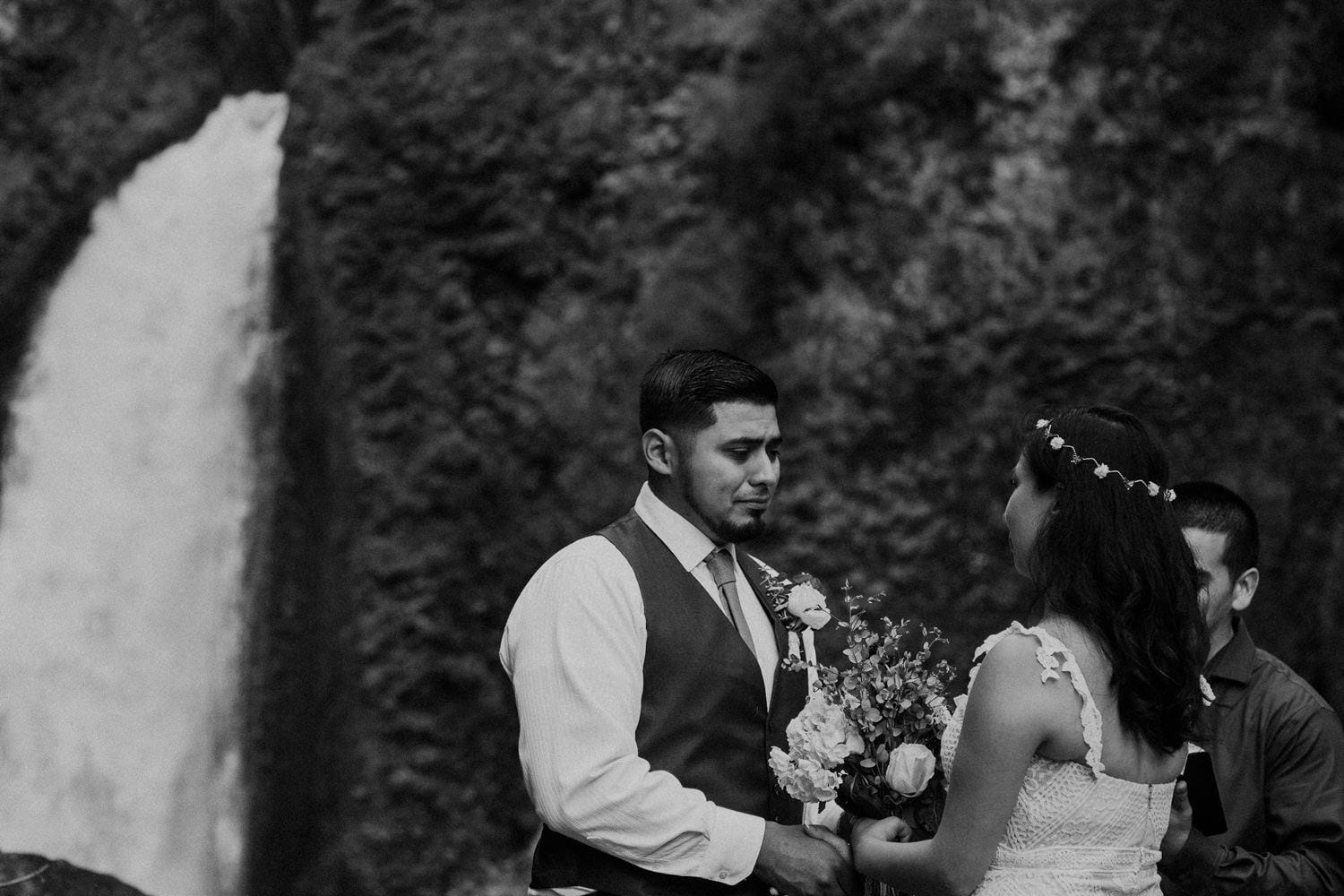 black and white crying groom in front of Wahclella Falls Oregon Columbia River Gorge elopement