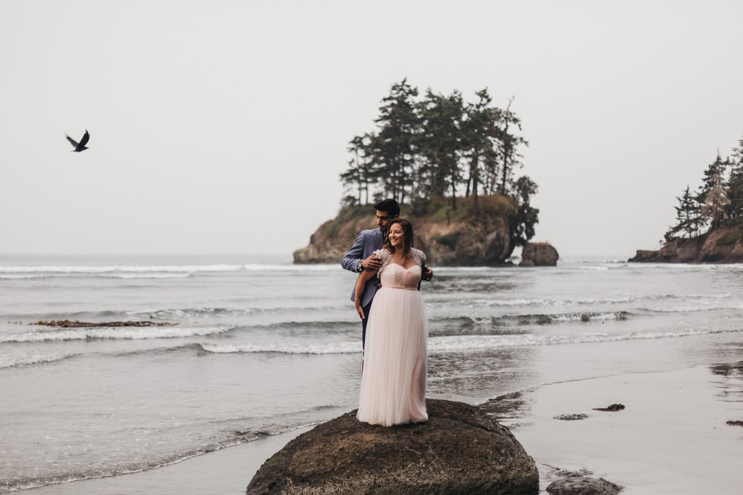 bird flying over couple on the olympic peninsula elopement by marcela pulido portland oregon wedding and elopement photographer