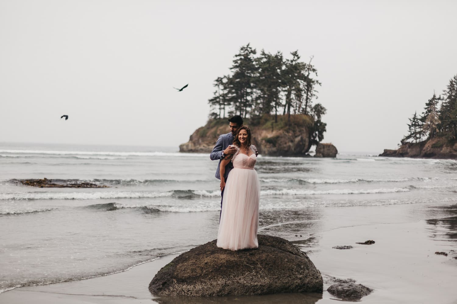 birds in the sky and newlywed couple with pink wedding dress on olympic peninsula elopement by marcela pulido portland oregon wedding and elopement photographer