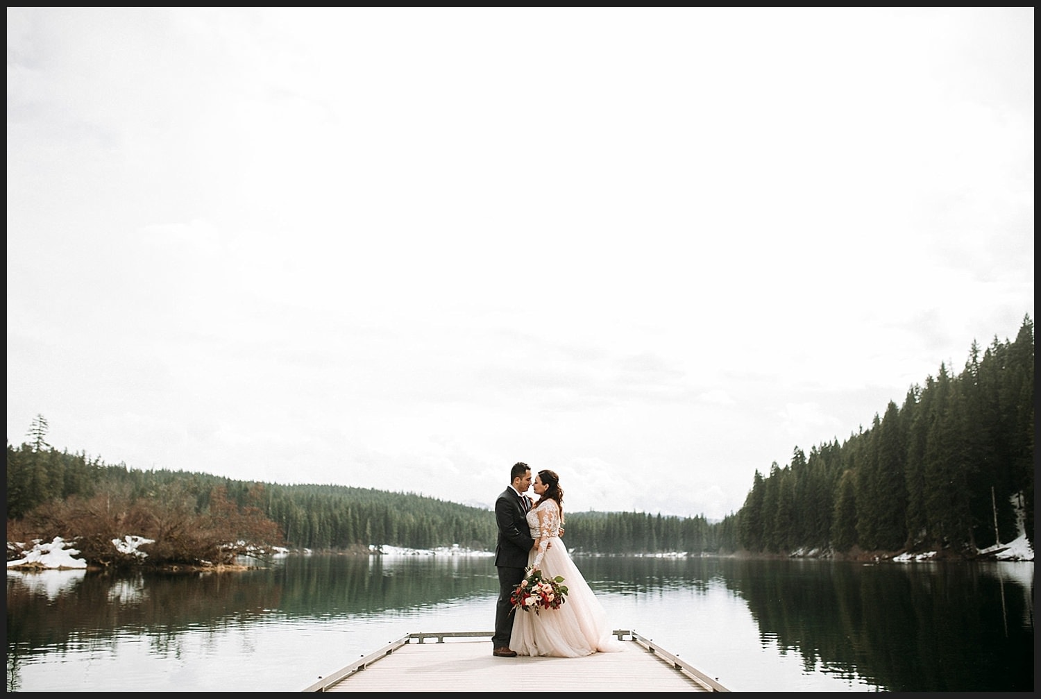 epic lake couples portrait lace long sleeve wedding dress and burgundy bouquet on Clear Lake Wedding