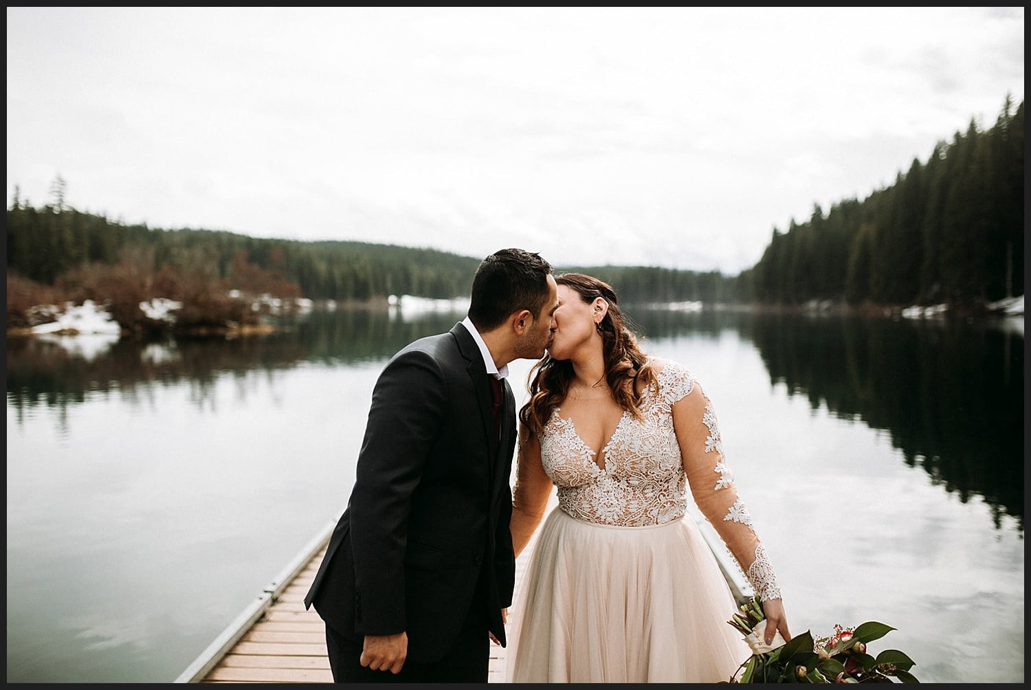 kiss on the dock at Clear Lake long sleeved wedding gown