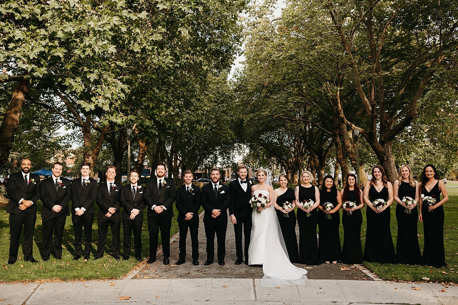 portrait of the bridal party at Green Lake bridesmaids in black and groomsmen in black 415 Westlake Wedding by Seattle Wedding Photographer Marcela Pulido