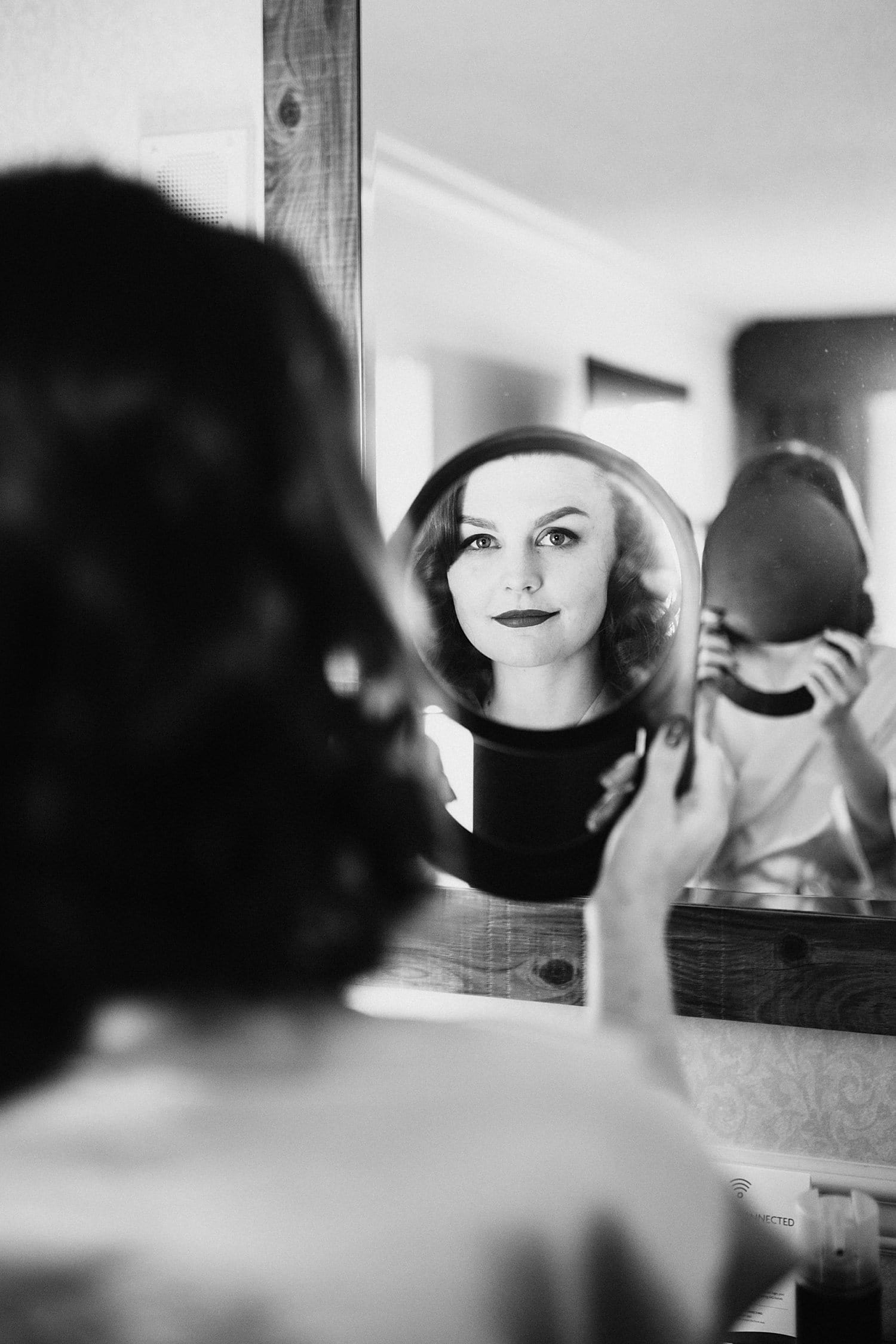 black and white portrait of bride looking at her reflection in a mirror Melody Ballroom wedding by Marcela Pulido Photography