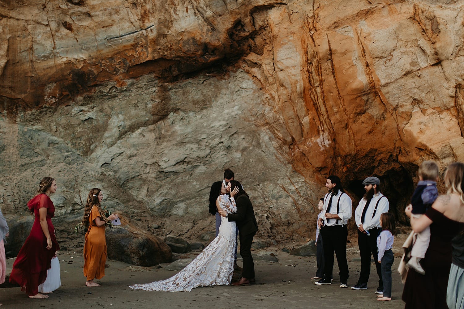 first kiss as husband and wife for this intimate ceremony at cape kiwanda elopement by marcela pulido portland oregon wedding photography
