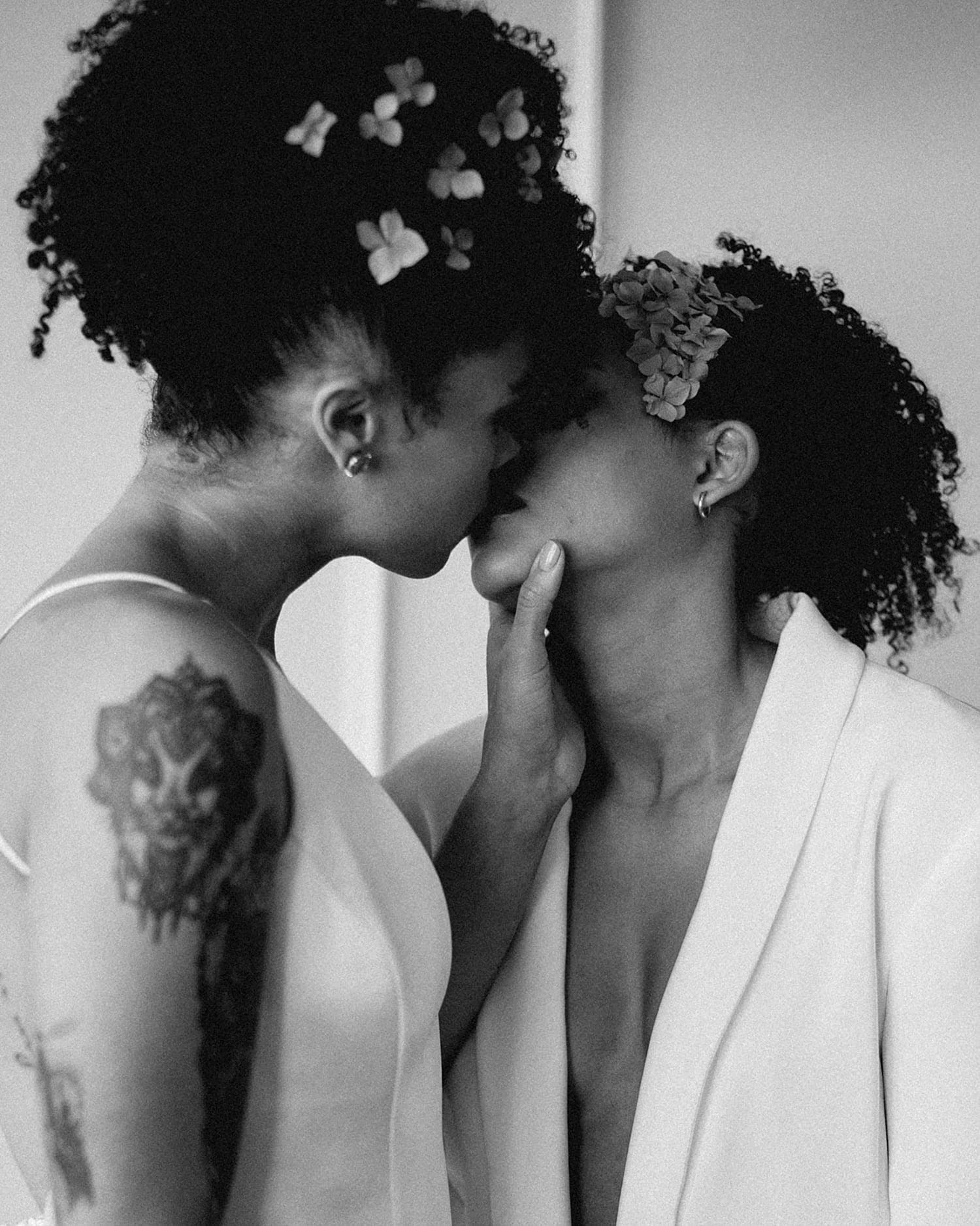 black and white romantic kiss beautiful same sex lesbian lgbtq+ friendly wedding couple newlywed wearing all white