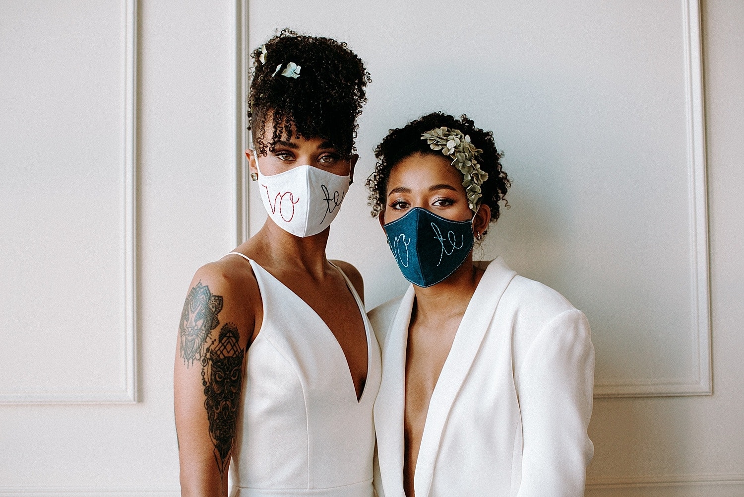 same sex lesbian lgbtq+ friendly wedding couple wearing all white wearing vote masks covid 19 pandemic