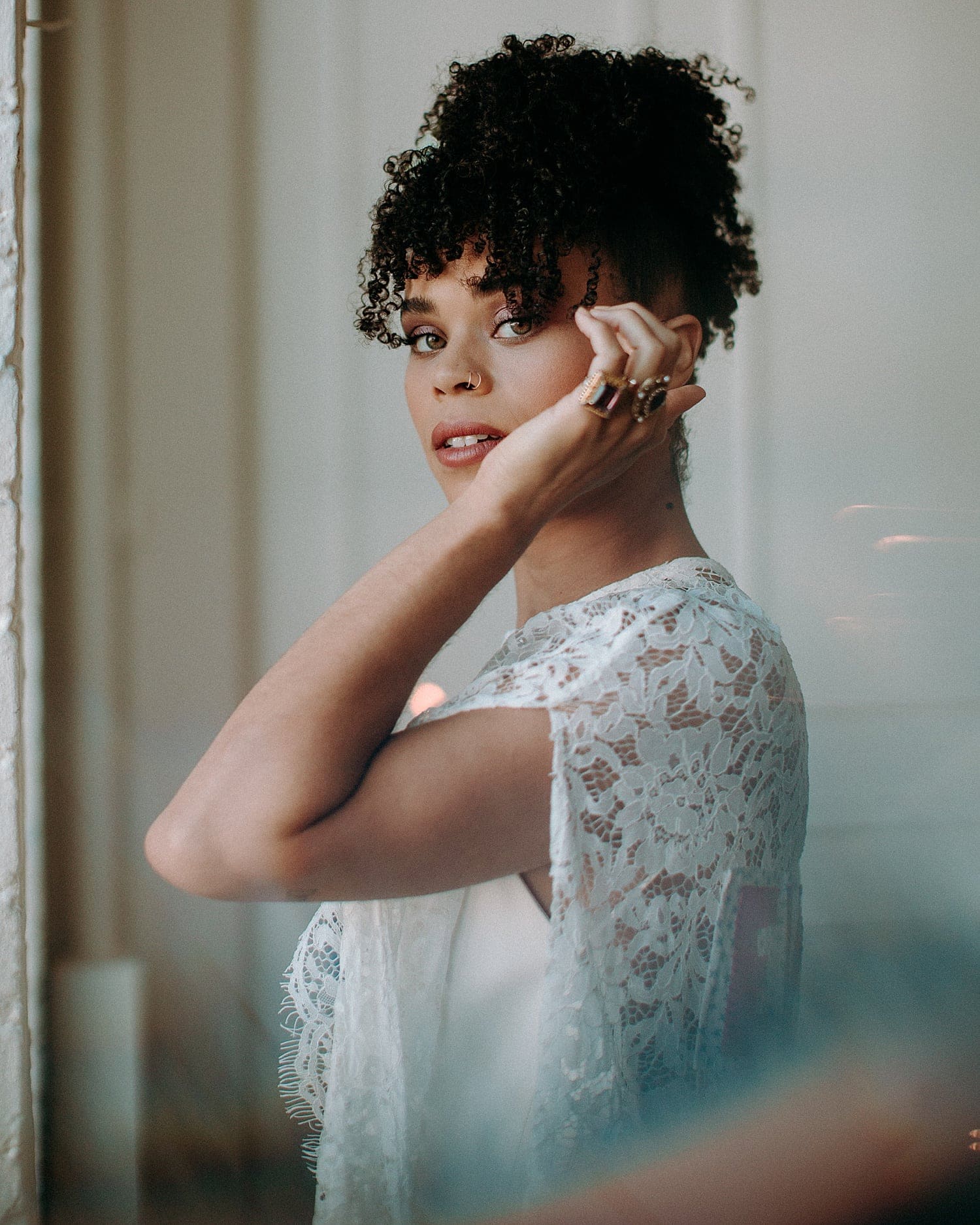 dreamy and ethereal portrait of a black bride with hazel eyes and curly hair wearing a lace cape by Claire La Faye