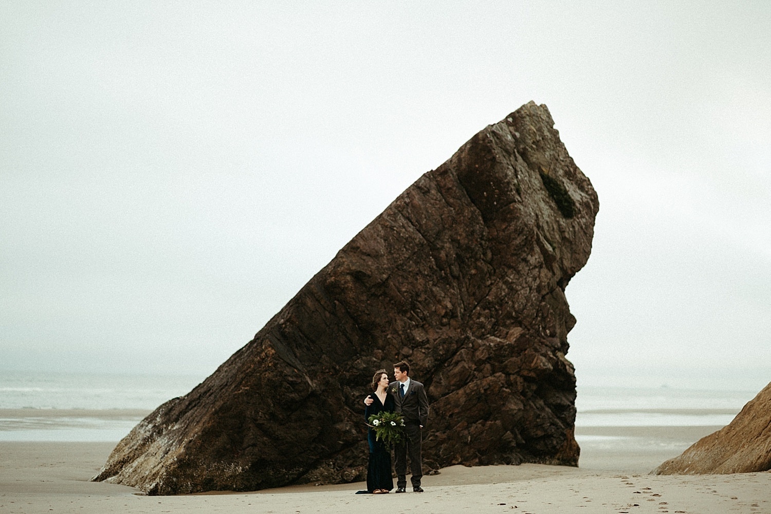 hero image of landscape giant rock on the beach oregon coast elopement hug point captured by marcela pulido photography portland oregon wedding elopement photographer