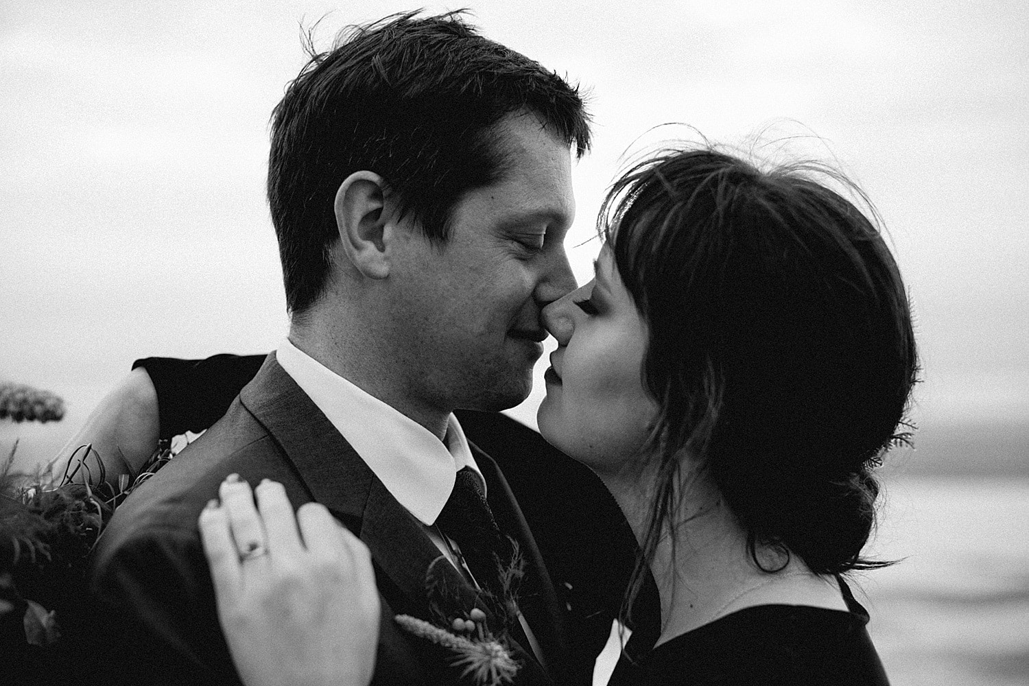 black and white portrait of couple kissing on the moody oregon coast captured by marcela pulido photography portland oregon wedding elopement photographer