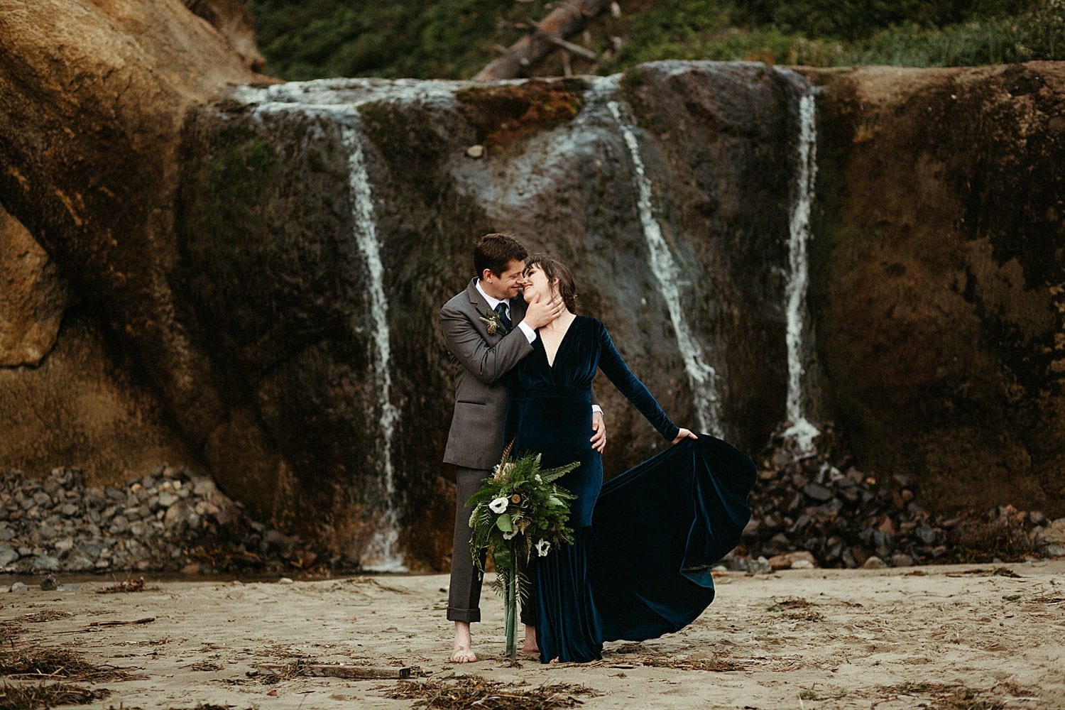 blue velvet wedding dress at a waterfall for oregon coast hug point elopement captured by marcela pulido photography portland oregon wedding and elopement photographer