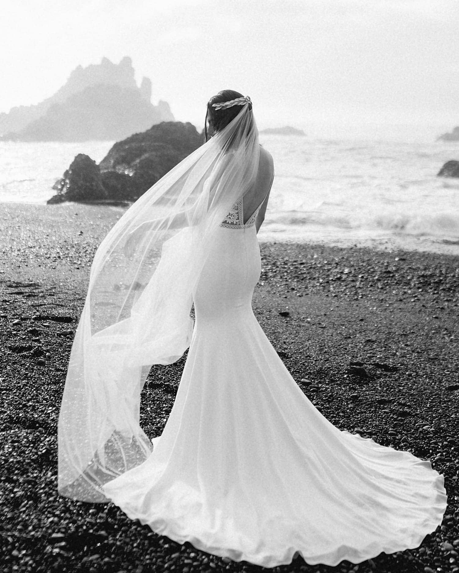black and white image of a bride on the oregon coast with her veil in the wind portland wedding photography pricing by marcela pulido