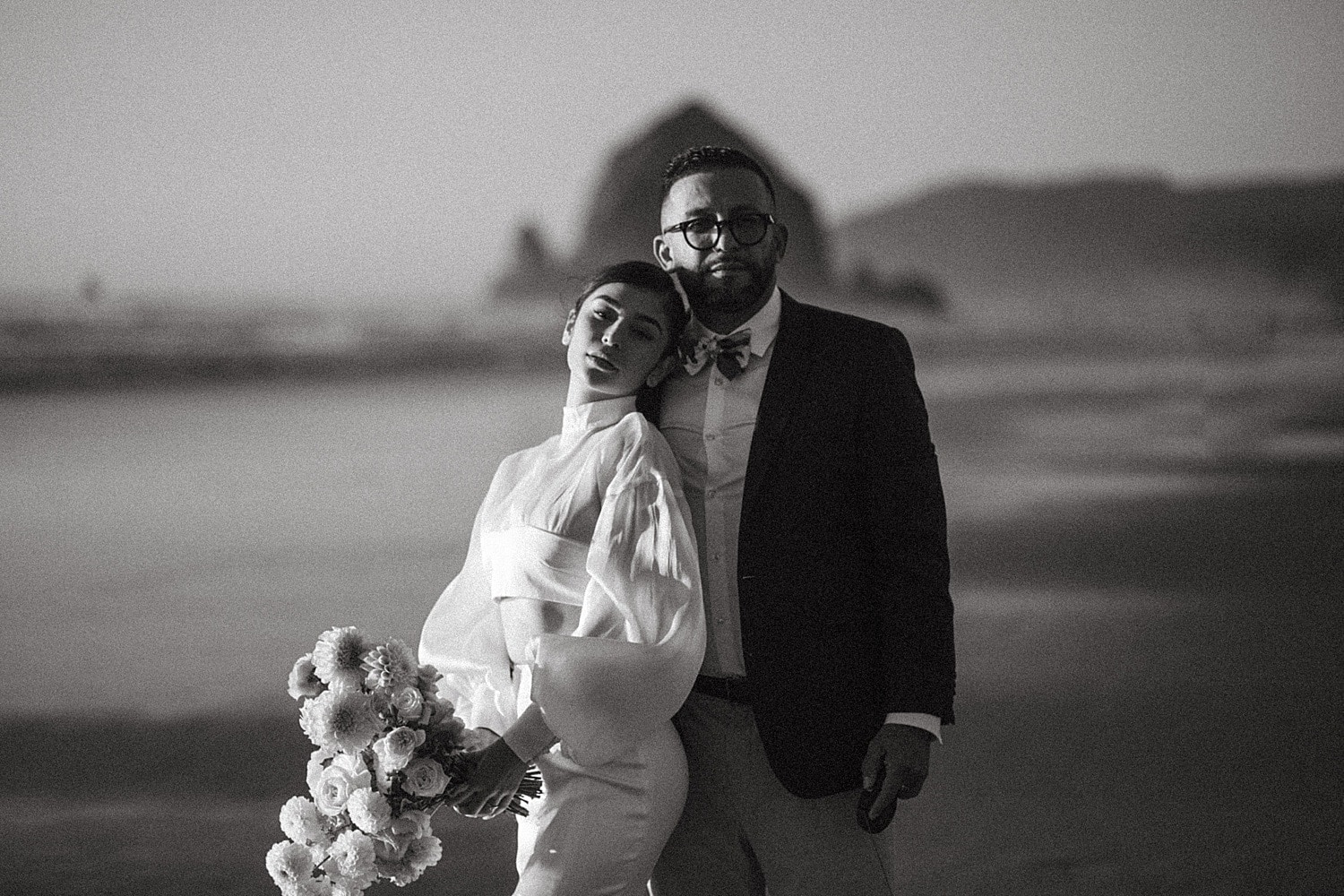 black and white intimate dreamy cinematic portrait of high end elegant luxury newlywed couple at cannon beach captured by marcela pulido portland oregon wedding photographer