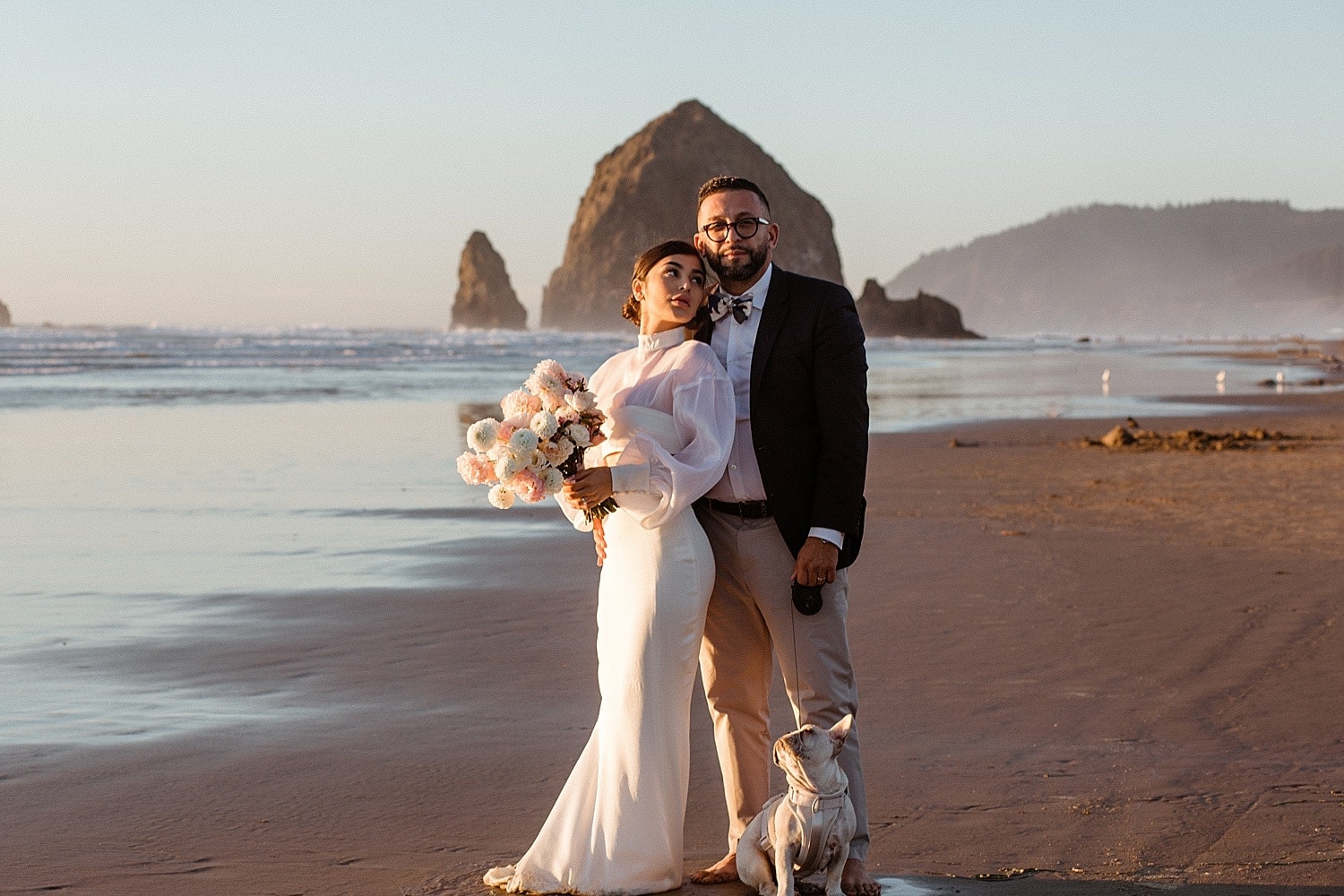 modern fashionable style of newlywed couple embracing at cannon beach on the oregon coast captured by marcela pulido portland oregon wedding photographer
