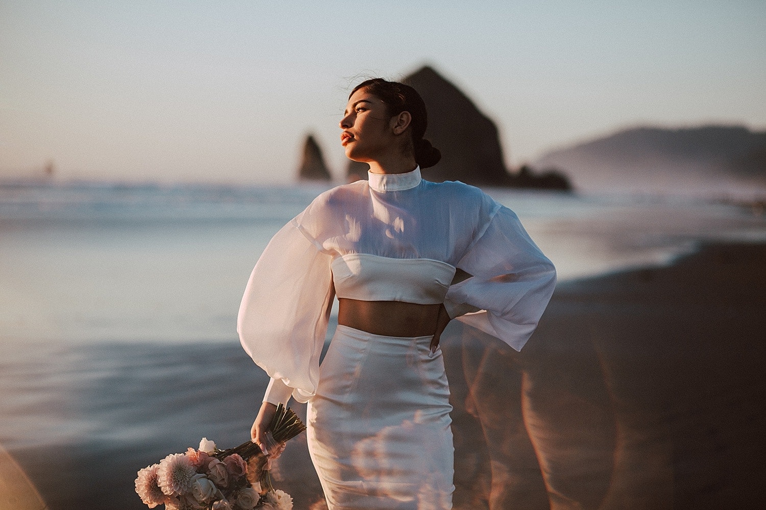 stunning latina bride striking a pose at cannon beach luxury two piece wedding gown captured by marcela pulido portland oregon wedding photographer