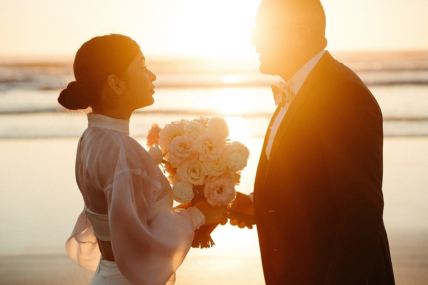 dreamy golden hour portrait of high end luxury elegant newlywed latino couple at cannon beach elopement captured by marcela pulido portland oregon wedding photographer