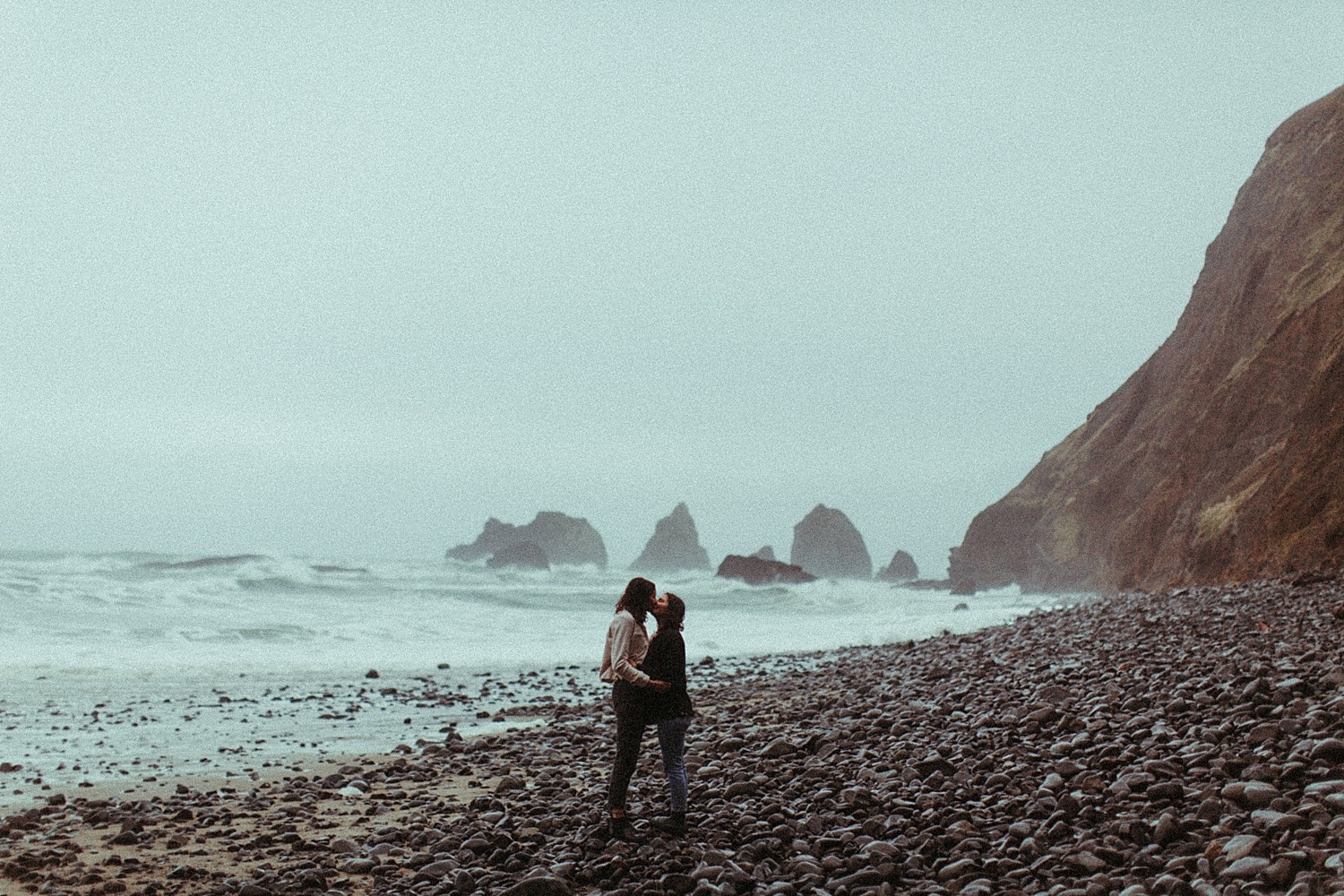 vintage colored cinematic photograph of a same sex lesbian couple on the oregon coast by Marcela Pulido Portland Wedding Photographer