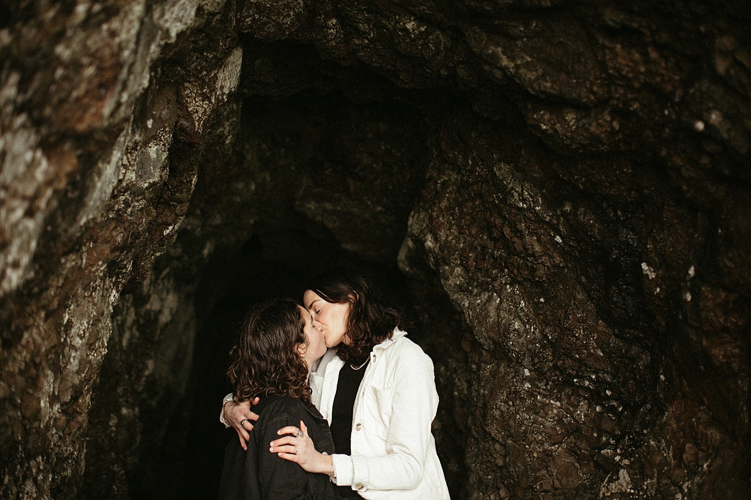same sex lesbian couple embracing a kissing on the oregon coast by Marcela Pulido Portland Wedding Photographer