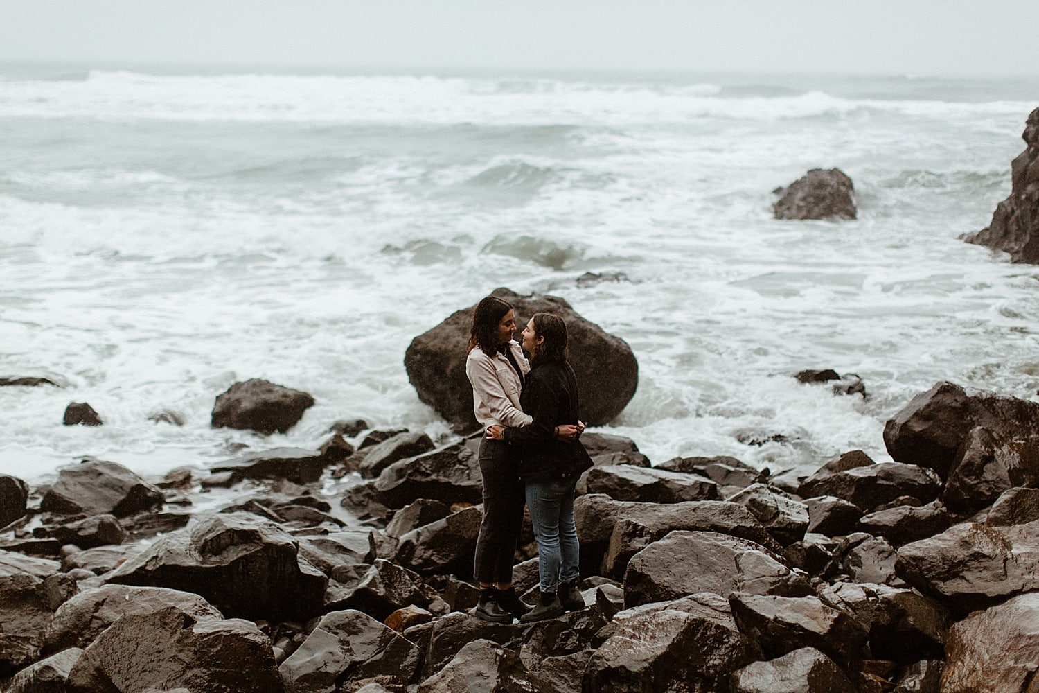 stunning landscape photo of a same sex lesbian couple embracing on the Oregon Coast by Marcela Pulido Portland Wedding Photographer