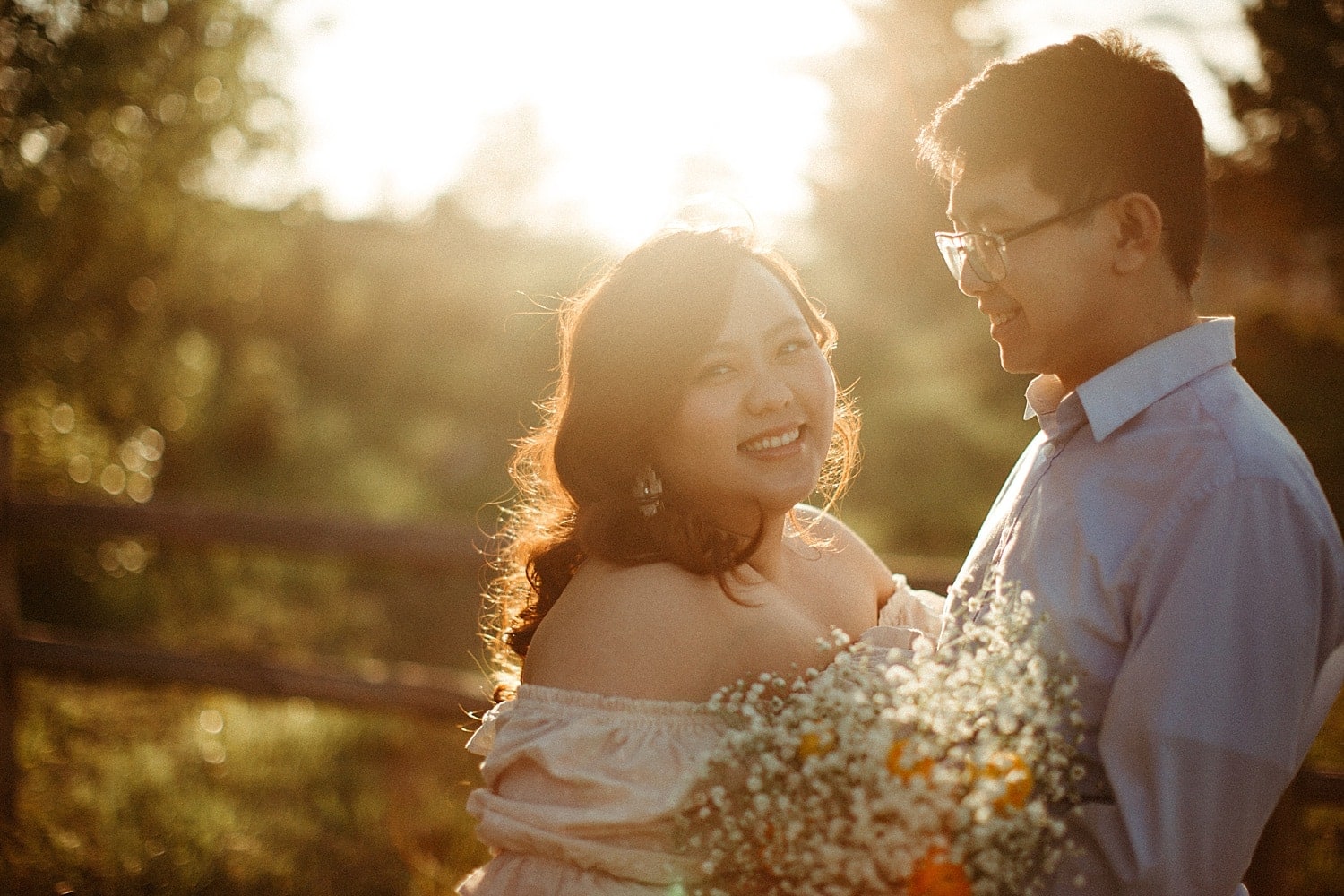 adorable asian couple embracing in a field during golden hour at powell butte park in portland oregon cottagecore engagement session