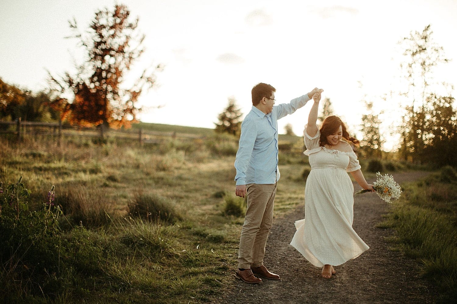 adorable asian couple twirling in a field during golden hour at powell butte park in portland oregon cottagecore engagement session
